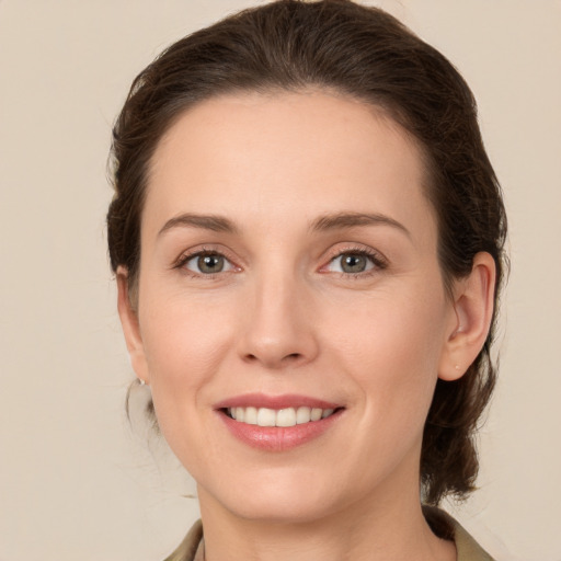 Joyful white young-adult female with medium  brown hair and green eyes