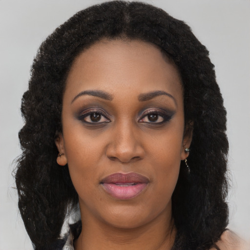 Joyful black young-adult female with long  black hair and brown eyes