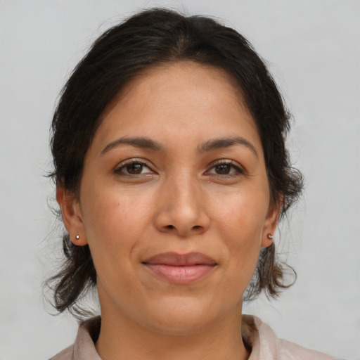 Joyful latino adult female with medium  brown hair and brown eyes