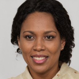 Joyful black adult female with medium  brown hair and brown eyes