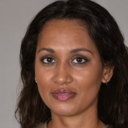 Joyful black adult female with medium  brown hair and brown eyes