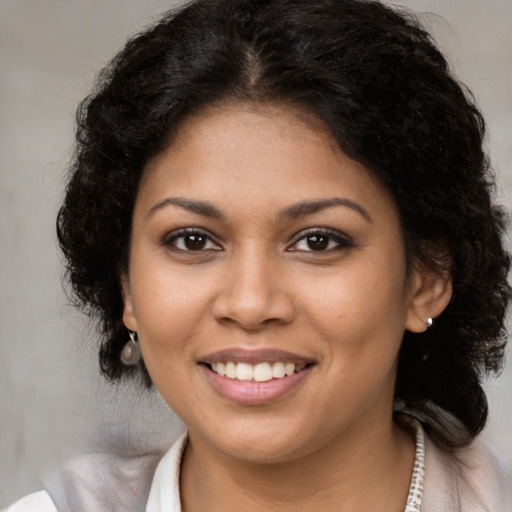Joyful black young-adult female with medium  brown hair and brown eyes