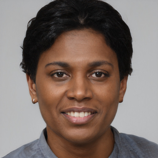 Joyful black young-adult female with short  black hair and brown eyes
