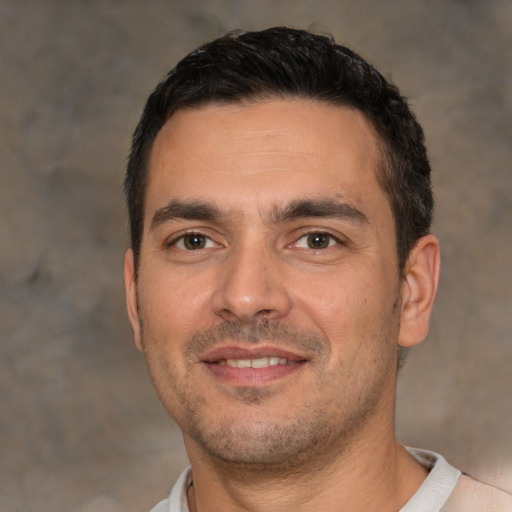 Joyful white young-adult male with short  black hair and brown eyes