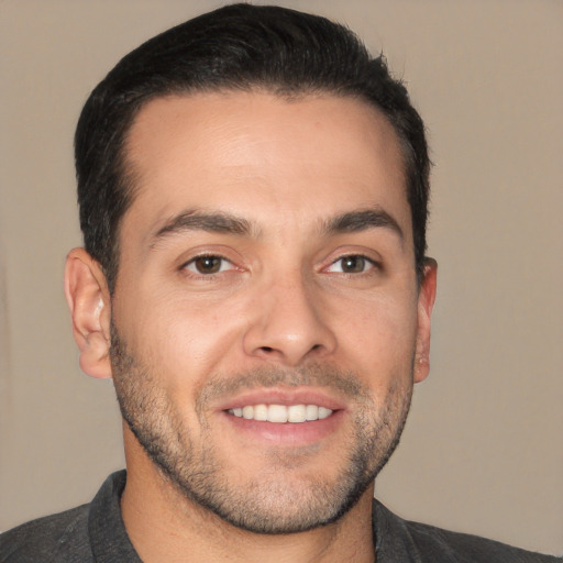 Joyful white young-adult male with short  black hair and brown eyes