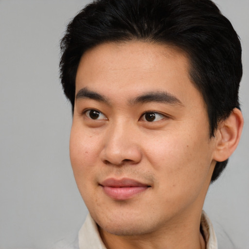 Joyful asian young-adult male with short  brown hair and brown eyes