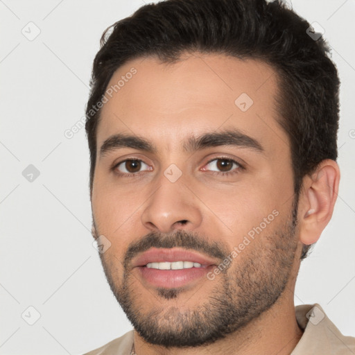 Joyful white young-adult male with short  brown hair and brown eyes