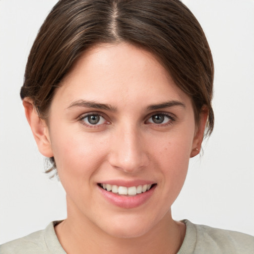 Joyful white young-adult female with short  brown hair and grey eyes