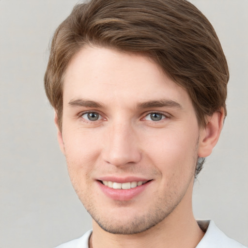 Joyful white young-adult male with short  brown hair and grey eyes