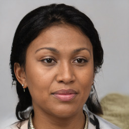 Joyful latino adult female with medium  brown hair and brown eyes