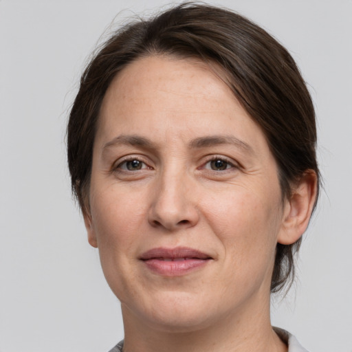 Joyful white adult female with medium  brown hair and grey eyes