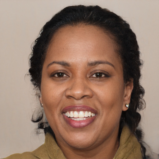 Joyful black adult female with long  brown hair and brown eyes
