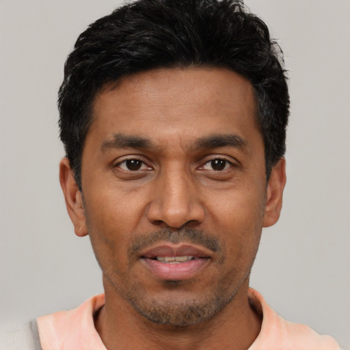 Joyful latino adult male with short  black hair and brown eyes