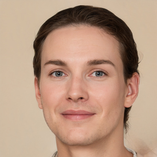 Joyful white young-adult male with short  brown hair and grey eyes