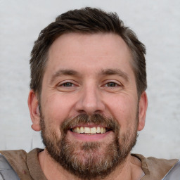 Joyful white adult male with short  brown hair and brown eyes