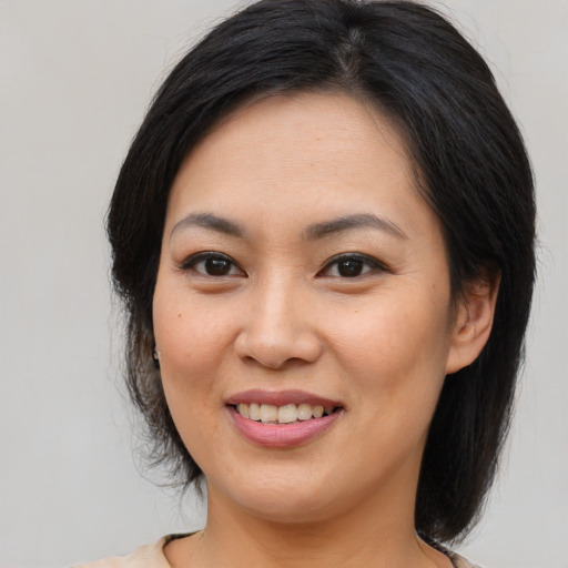 Joyful asian young-adult female with medium  brown hair and brown eyes