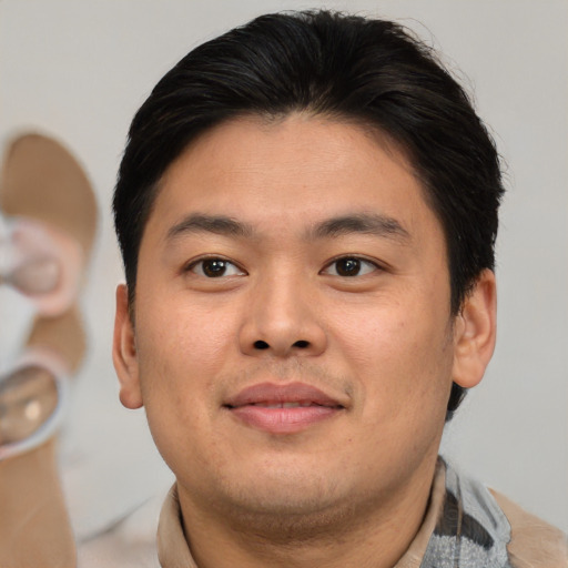Joyful asian young-adult male with short  brown hair and brown eyes