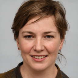 Joyful white adult female with medium  brown hair and blue eyes