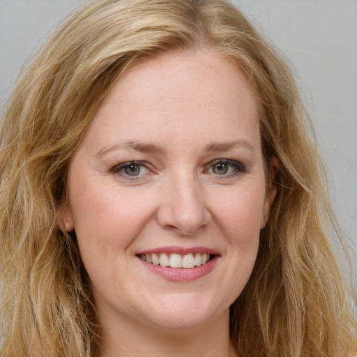 Joyful white young-adult female with long  brown hair and blue eyes