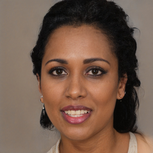 Joyful black young-adult female with long  black hair and brown eyes