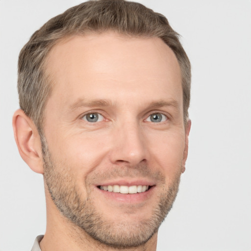 Joyful white adult male with short  brown hair and grey eyes