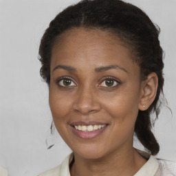 Joyful black young-adult female with long  brown hair and brown eyes