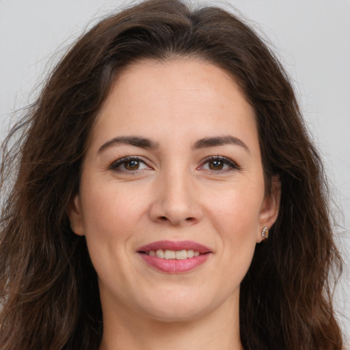 Joyful white young-adult female with long  brown hair and brown eyes