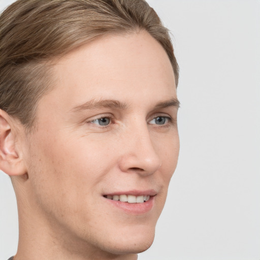 Joyful white young-adult male with short  brown hair and grey eyes