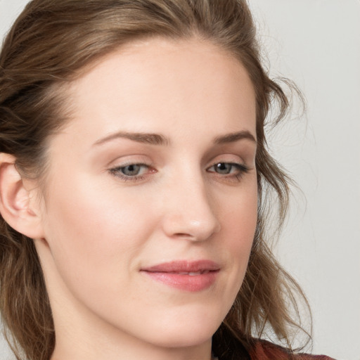 Joyful white young-adult female with long  brown hair and blue eyes