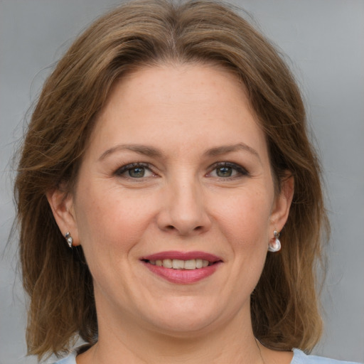 Joyful white adult female with medium  brown hair and grey eyes