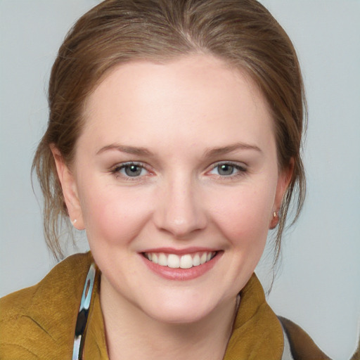 Joyful white young-adult female with medium  brown hair and blue eyes