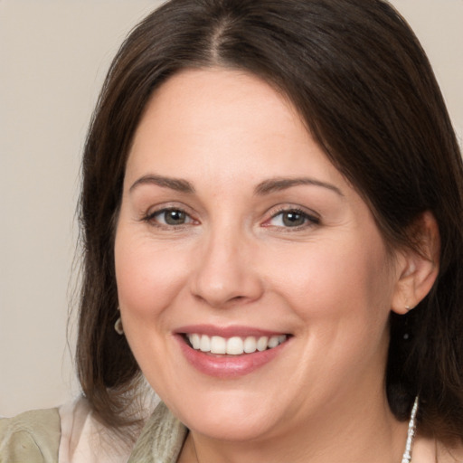 Joyful white adult female with medium  brown hair and brown eyes