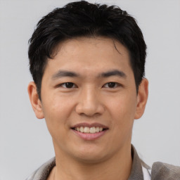 Joyful asian young-adult male with short  black hair and brown eyes