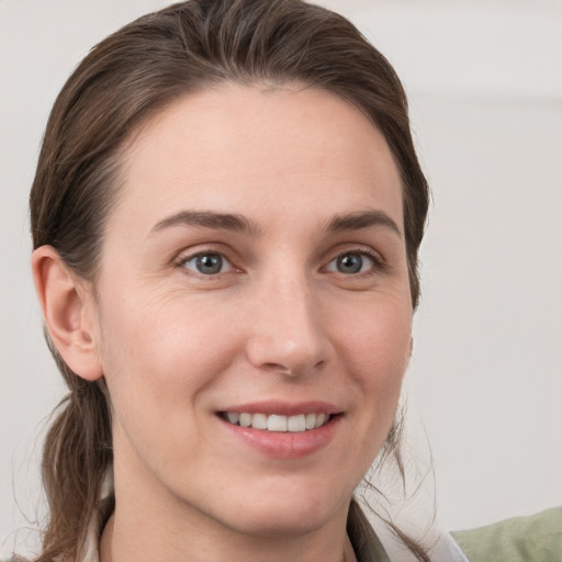 Joyful white young-adult female with medium  brown hair and grey eyes