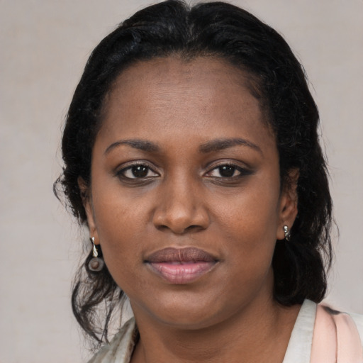 Joyful black young-adult female with long  black hair and brown eyes