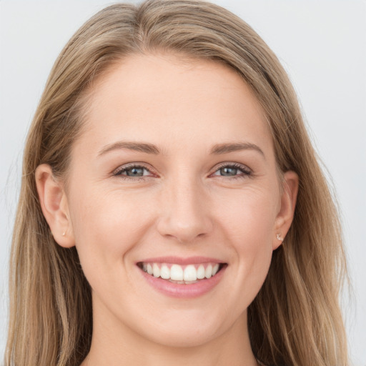 Joyful white young-adult female with long  brown hair and blue eyes