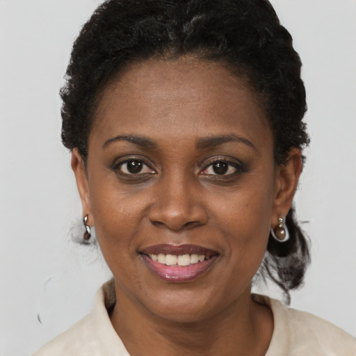 Joyful black adult female with short  black hair and brown eyes
