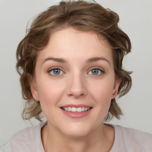 Joyful white young-adult female with medium  brown hair and blue eyes