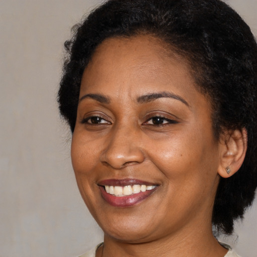 Joyful black young-adult female with medium  brown hair and brown eyes