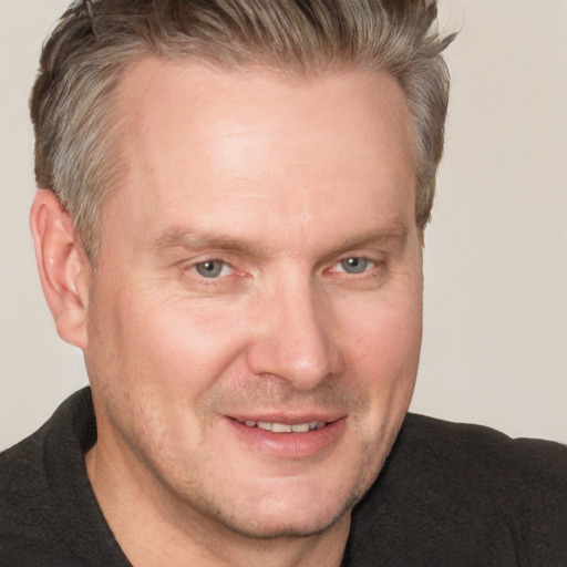 Joyful white adult male with short  brown hair and grey eyes