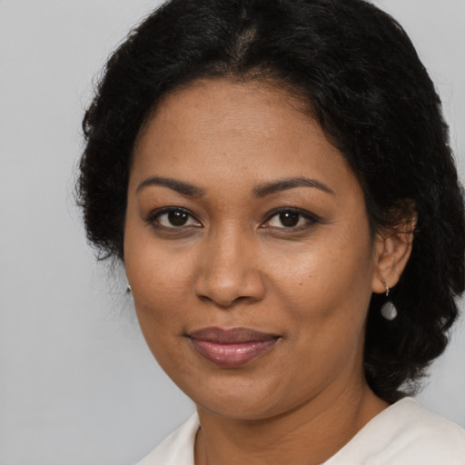 Joyful black adult female with long  brown hair and brown eyes