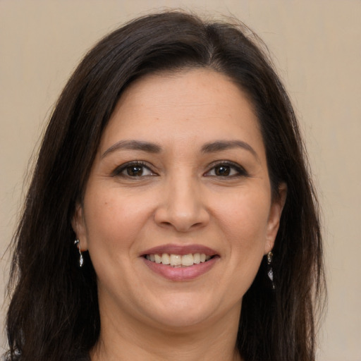 Joyful white adult female with long  brown hair and brown eyes