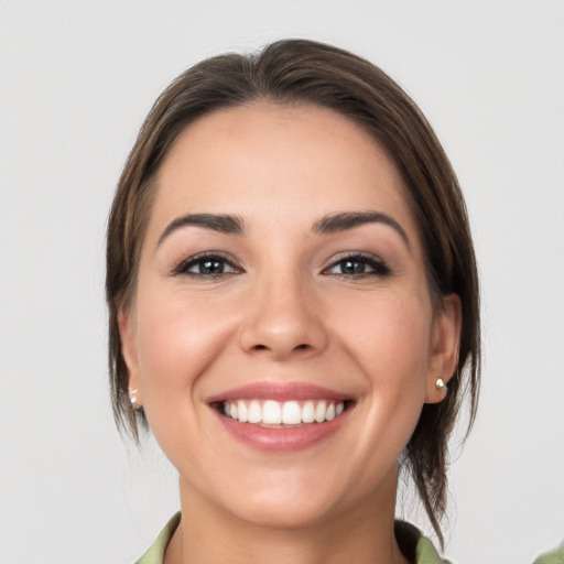 Joyful white young-adult female with medium  brown hair and grey eyes