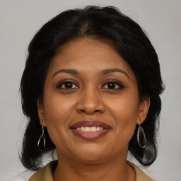 Joyful black adult female with medium  brown hair and brown eyes