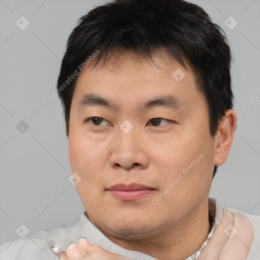 Joyful asian young-adult male with short  brown hair and brown eyes
