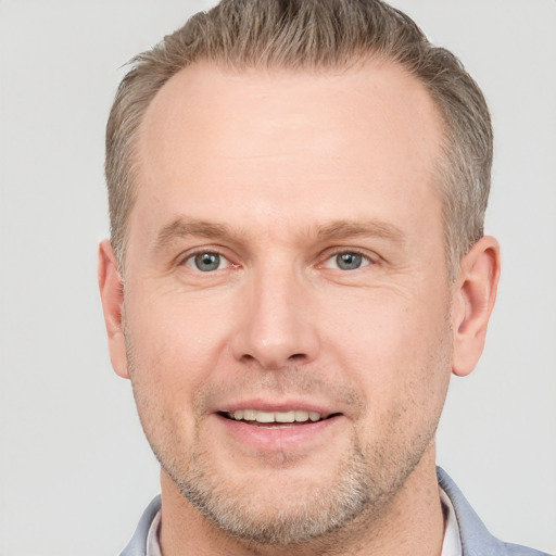 Joyful white adult male with short  brown hair and grey eyes