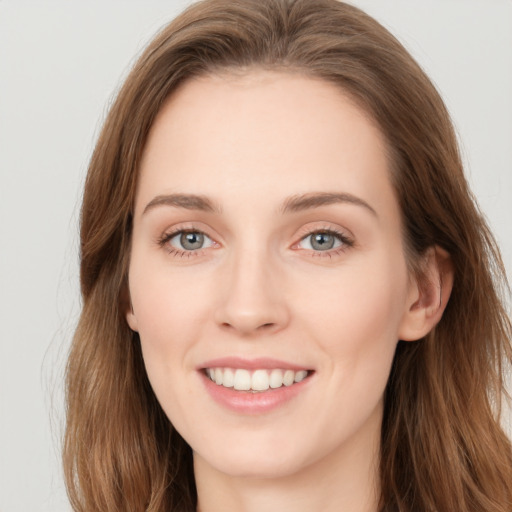 Joyful white young-adult female with long  brown hair and blue eyes