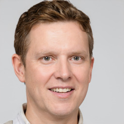 Joyful white adult male with short  brown hair and grey eyes