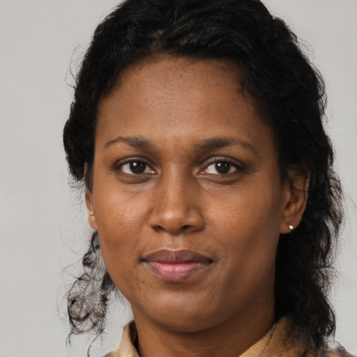 Joyful black adult female with medium  brown hair and brown eyes