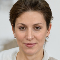 Joyful white adult female with medium  brown hair and grey eyes